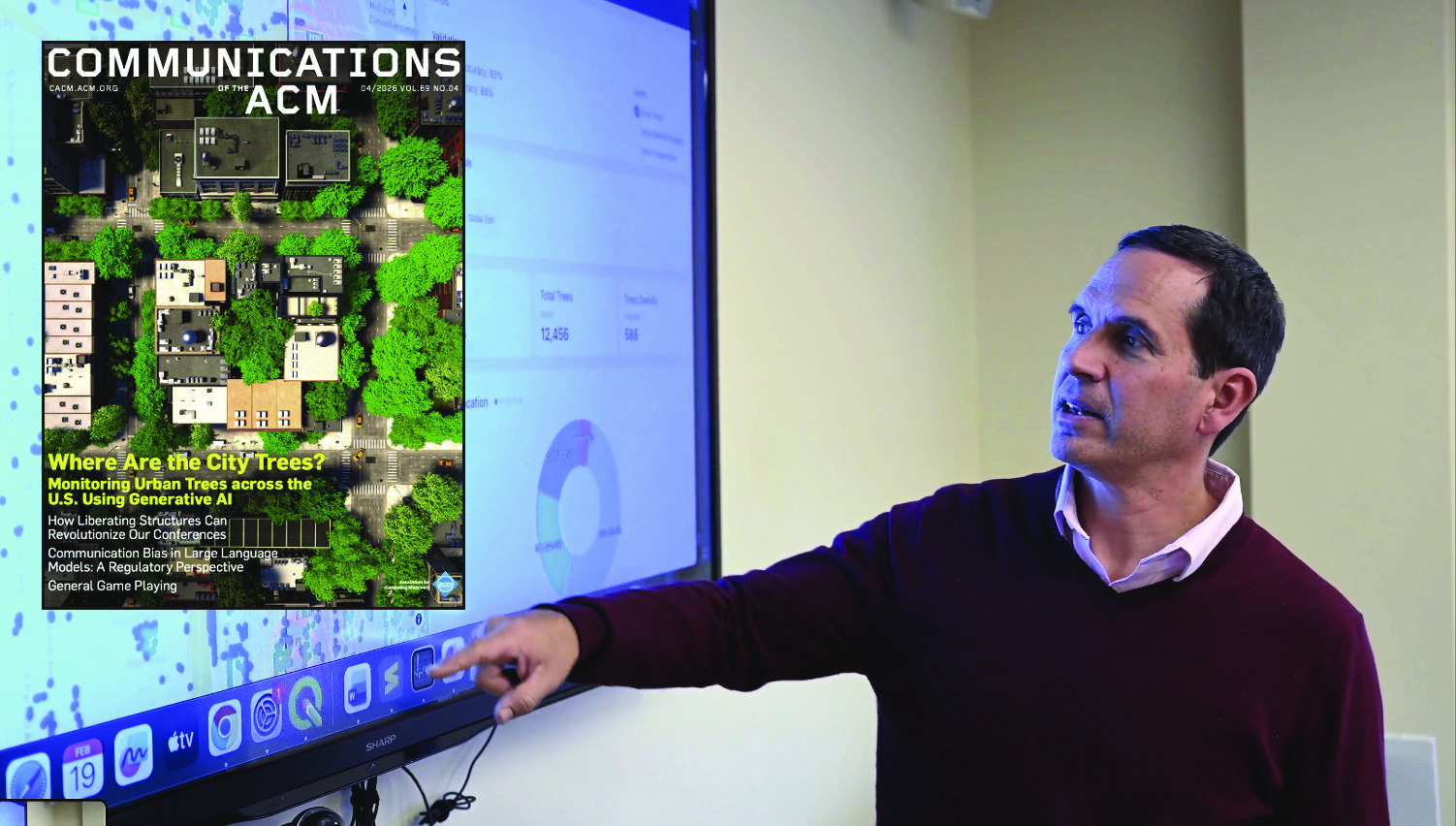 Professor Daniel Aliaga pointing at a screen with a graphic of 3-D modeled trees. Layover of CACM Cover.