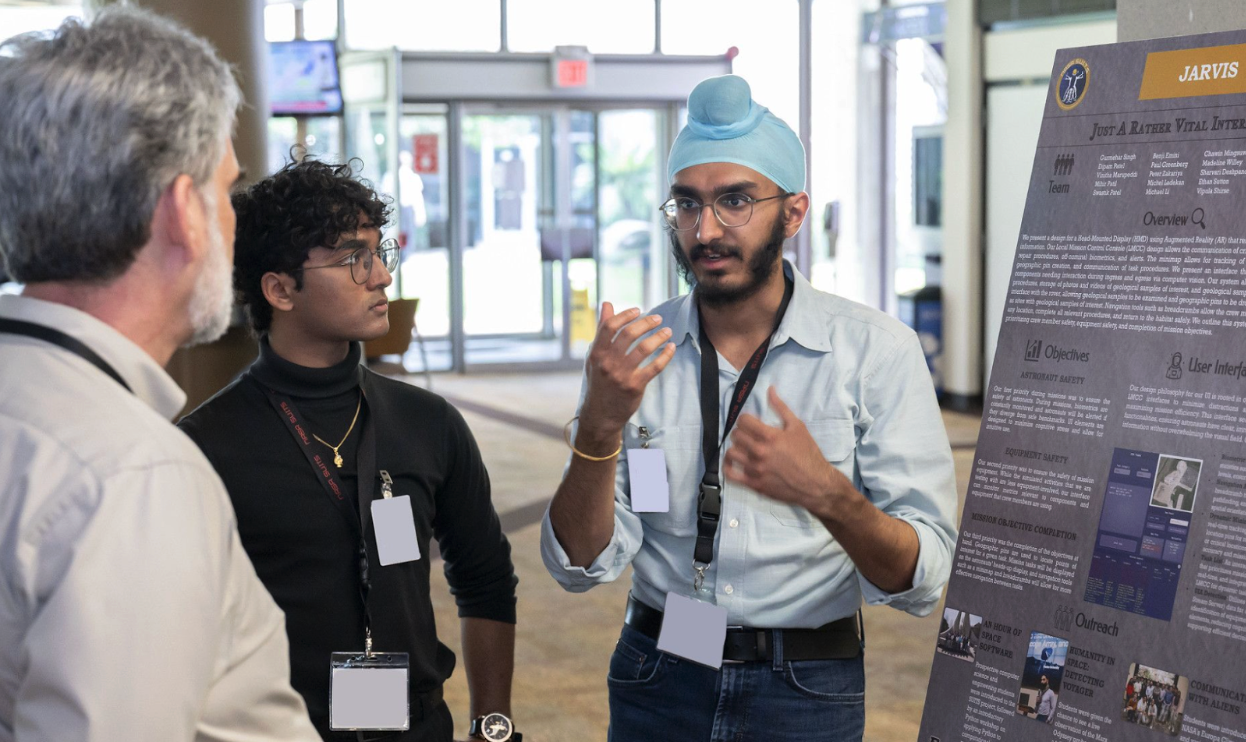From right to left: Gurmehar Singh and Swastik Patel explain the team’s work to NASA Employees at last year’s SUITS Test Week Poster Session in May 2024. Photo Credit: NASA - James Blair