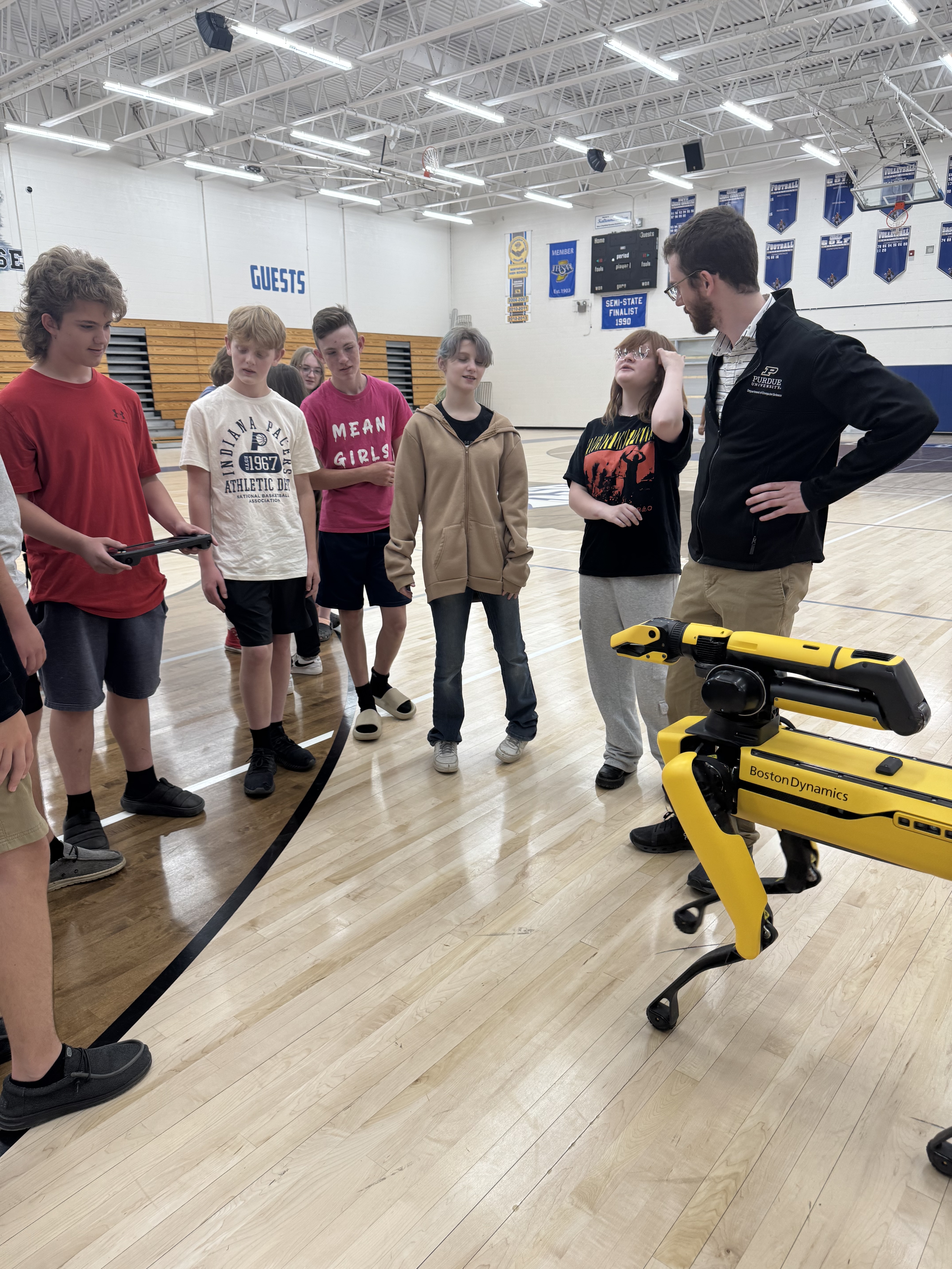 professor and students interacting with robotic dog